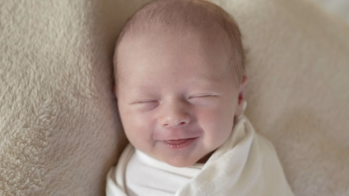 newbornfoto van een lachende baby, van 10 dagen jong, gemaakt in de studiosetting.